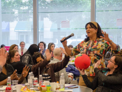 Woman speaking in front of community members