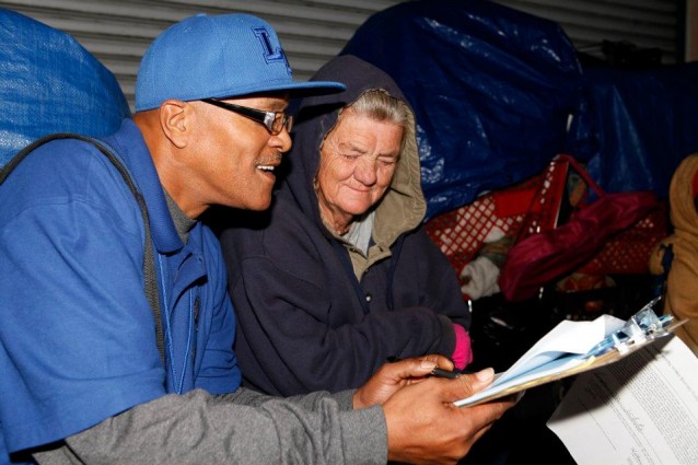 Man surveying homeless woman