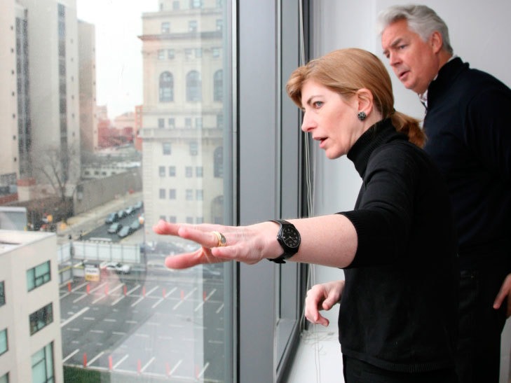 Photo of Rosanne explaining the mission at a window