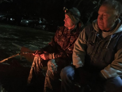 Adult men sitting by fire