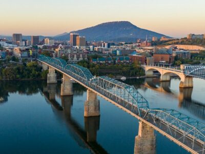 The city of Chattanooga is on the banks of a river with two bridges stretching across the water.