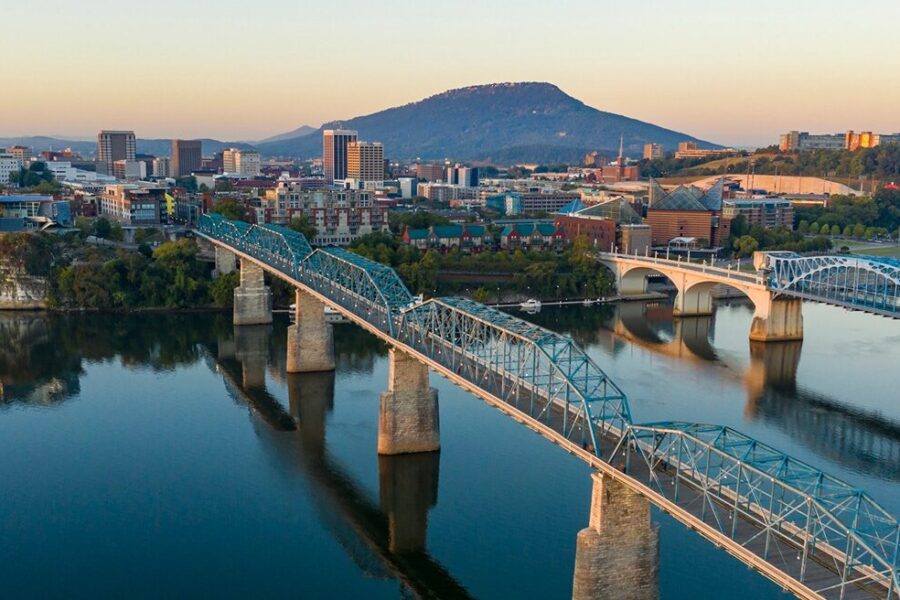 The city of Chattanooga is on the banks of a river with two bridges stretching across the water.