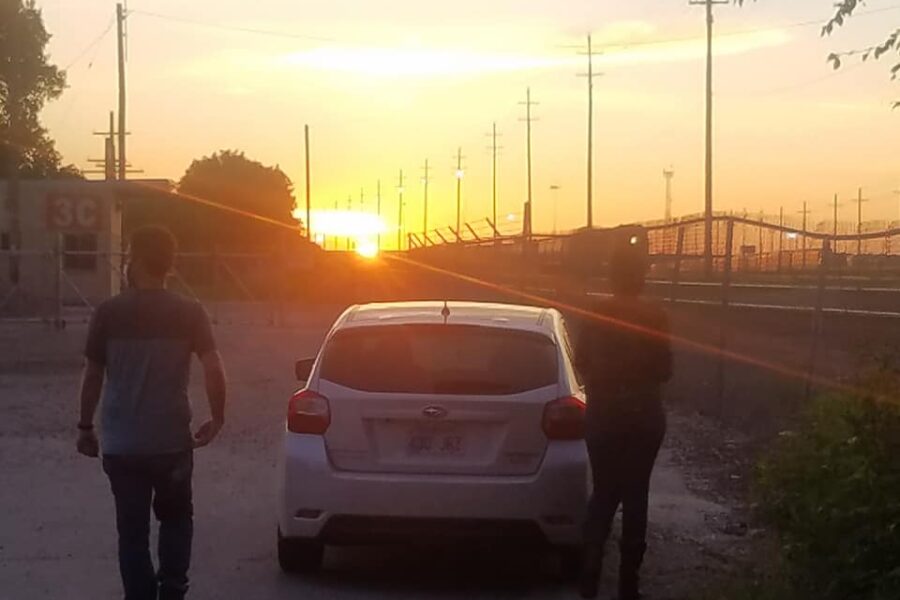 Outreach workers walking from car into sunset
