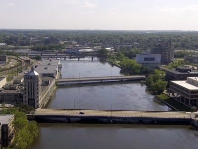 Rockford, IL spreads out across two separate banks of a river, intersected by two low bridges.