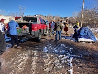 Outreach team walking by tent and truck on wintry day