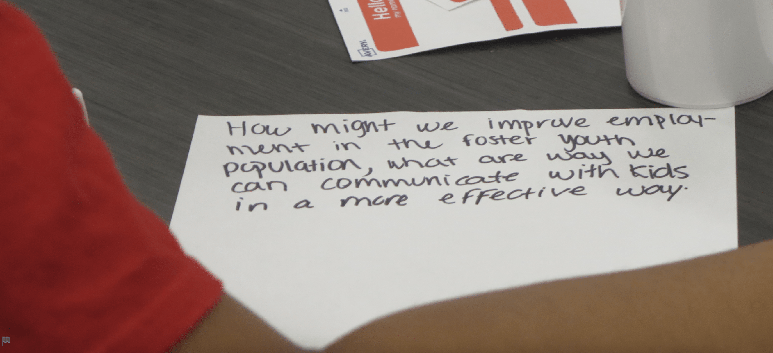 Index card with handwritten text saying: "How might we improvement employment in the foster youth population, what are ways we can communicate with kids in a more effective way."