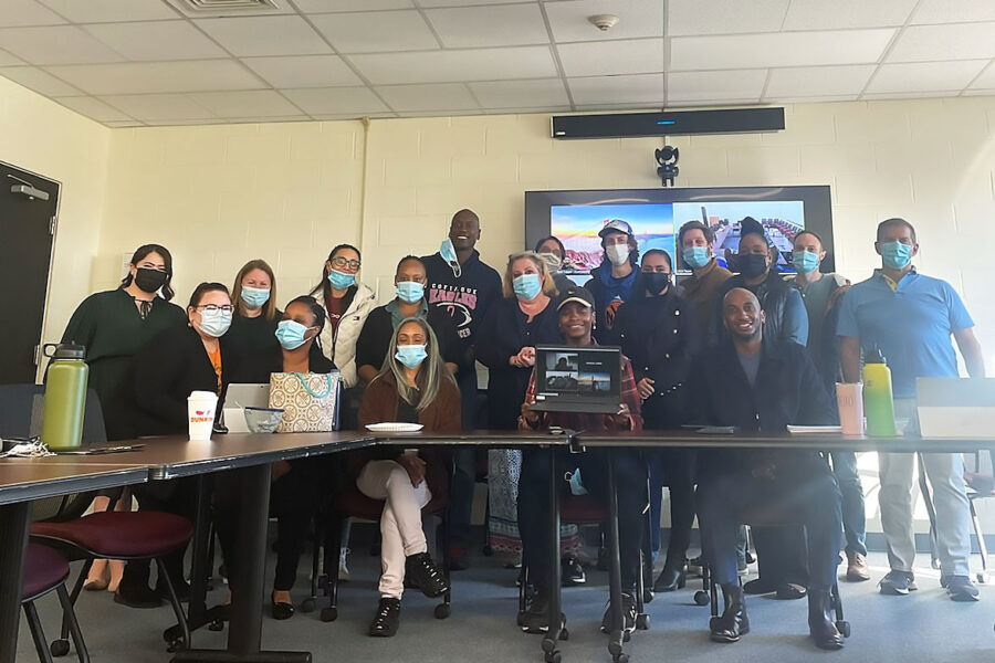 Long Island Coalition for the Homeless team sitting around a desk with masks on posing for the picutre