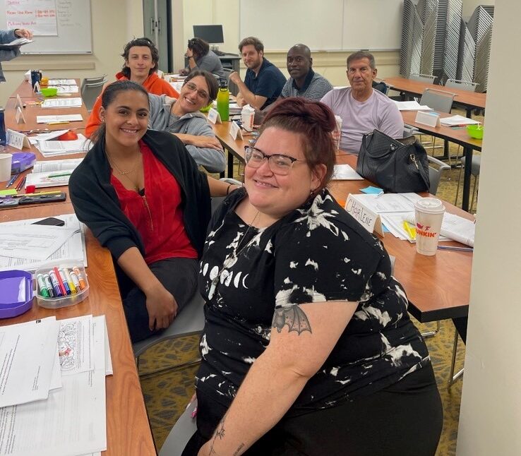 Team of people sitting at desks smiling